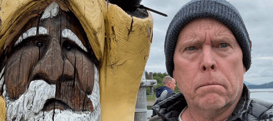 Todd looking grumpy next to a wooden sailor statue.